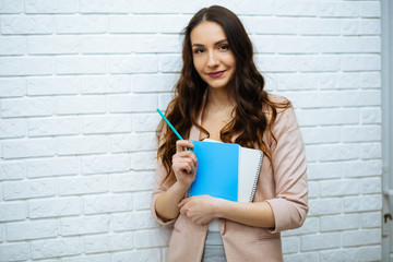 businesswoman standing near white brick wall © ostap_davydiak