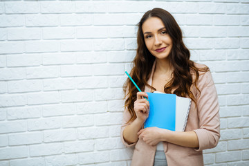 businesswoman standing near white brick wall © ostap_davydiak