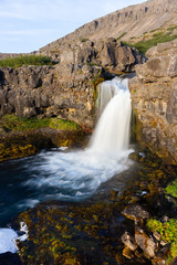 Fototapeta na wymiar Iceland waterfall closeup view of the gods cliff with long exposure smooth motion of water in summer landscape
