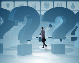 Businessman in uncertainty concept with question marks