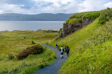 Fototapeta na wymiar Tourists walking at the eastern cape of Mull island, Duart castle hill, Scotland