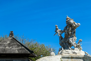 Obraz premium A close up on an ornated roof of Uluwatu temple, Bali Indonesia. It represents a monkey king fighting with smaller monkeys and other creatures. Hinduism. Traditional and cultural site