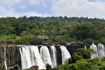 Fototapeta na wymiar Iguazu roaring waterfalls against a jungle and gray sky