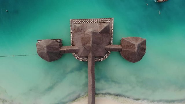 Top View on Beautiful thatch stilt house at Zanzibar Nungwi beach at evening time with blue Indian ocean
