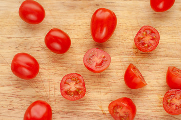 Ripe cherry tomatoes in a wooden cutting board, top view