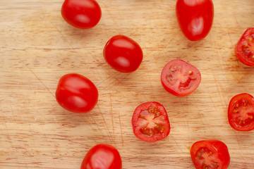 Ripe cherry tomatoes in a wooden cutting board, top view