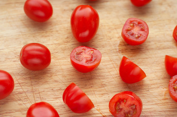 Ripe cherry tomatoes in a wooden cutting board, top view