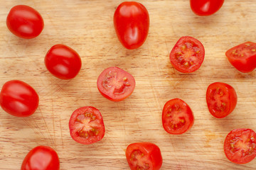 Ripe cherry tomatoes in a wooden cutting board, top view