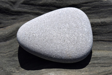 A smooth stone lies on an uneven surface. SPA and peace of mind.