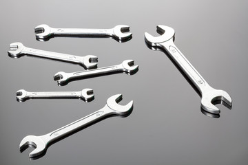 Set of wrenches on a gray background. Mirror surface. View on a plane.Copy space.