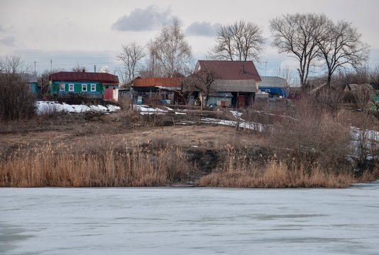 Spring scene with authentic village on the hill. Snow melting.