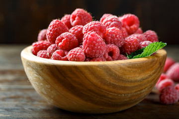 Fresh raspberry in a wooden plate.