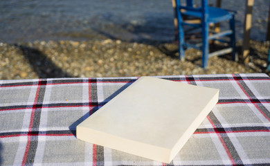 Empty white book on patterned table. Relaxation mood, cultural activity. Freedom, information,...