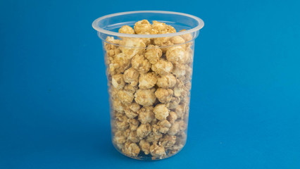 a pack of sweet popcorn standing in the center on a blue background