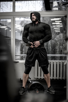 Mental And Physical Growth Concept Of Hard Workout Training In Gym By Strong Young Athlete Caucasian Man Wearing Hoodie And Powerlifting Belt Near Barbell