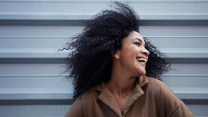  pretty young black woman with afro hair laughing and enjoying