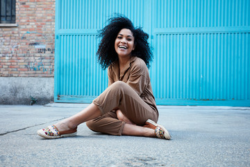  pretty young black woman with afro hair laughing and enjoying