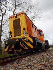 Une petite locomotive thermique avec un tampon centrale et une voiture corail.