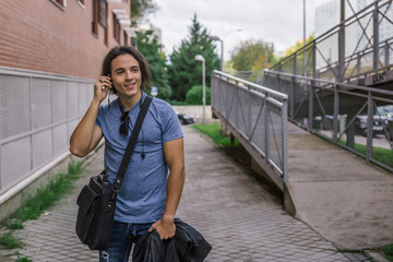 Obraz premium Handsome young man with casual style smiles while listening to music with his headphones