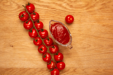 Ripe cherry tomatoes on a wooden board, top view with copy space