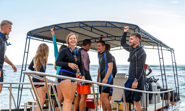 group of divers from diving center on a boat swim to the dive site, young boys and girls, an adult instructor, Asia Sri Lanka.