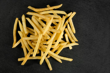 French fries on a dark background. View from above. Fast food.