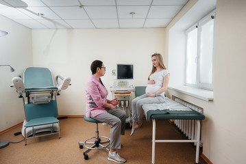 A pregnant girl is advised by a doctor after an ultrasound in the clinic. Medical examination