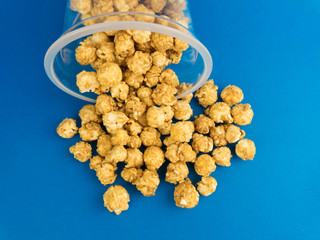 pile of popcorn spilled out of the packaging on a blue background