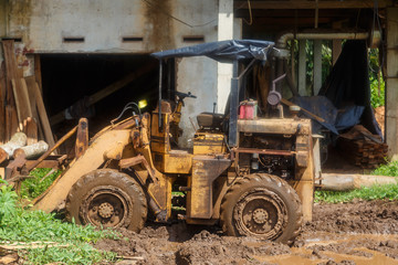 Asian sawmill in tropics, mud, puddles, tractor, Sri Lanka, day, Sunny