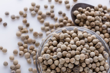 white peppercorns in glass bowl with spoon