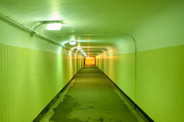 Underground pedestrian tunnel with green walls.