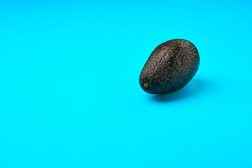 A fresh avocado on blue background.