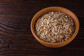 raw oatmeal on a wooden rustic background