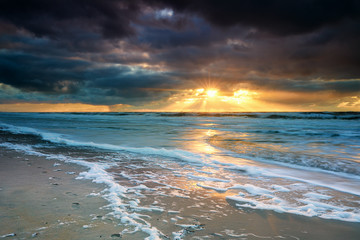 Obraz na płótnie Canvas dramatic sunset over North sea waves