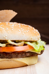 Burger macro from the side on a wooden background.