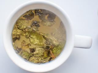 green tea leaves are brewed in a mug. the view from the top