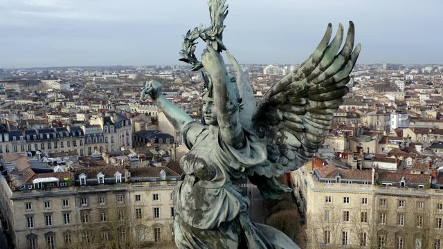 Close up of Liberty Angel Girondins monument in Bordeaux, France, with city panorama and Garonne river, Aerial orbit reveal shot