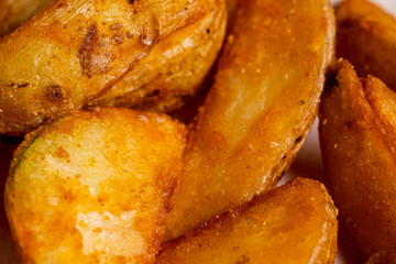Rustic fried potato in close-up on a paper background.