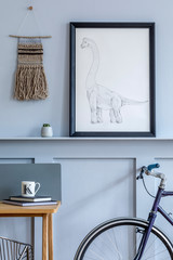 Stylish scandinavian living room with mokc up poster frame on the shelf, wooden desk, bicycle, office supplies and personal accessories in design home decor.