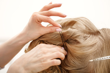 Fototapeta premium Makeup artist, hair professional stylist makes young beautiful bride bridal makeup before wedding in a morning