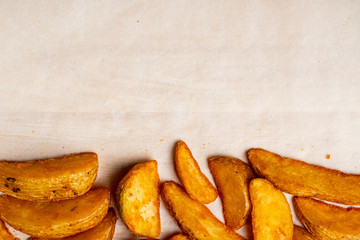 Rustic fried potatoes on a paper background. Copy space.