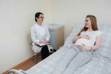 The doctor advises and serves a young pregnant girl in a medical clinic. Medical examination