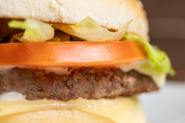 Burger on a white plate and wooden background.