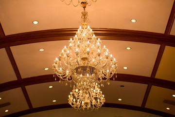 Huge crystal glass chandeliers hanging on ballroom dance in wedding ceremony date,decorated by victorian style