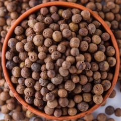 fresh spicy peppers allspice on white acrylic background