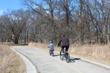 Father and daughter riding bicycles on the North Branch Trail at Miami Woods in Morton Grove, Illinois