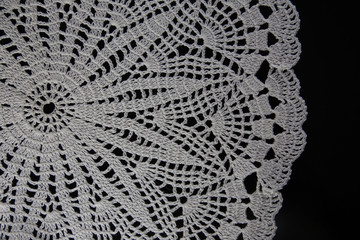 crocheted napkins, white lace on a black background