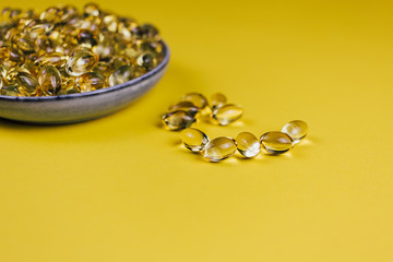 fish oil in capsules on a yellow background