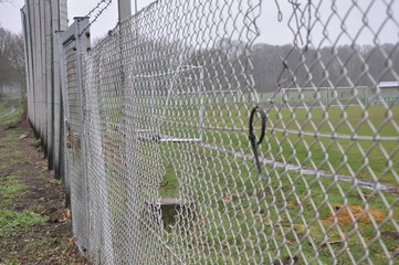 Fußballtor mit Zaun und Loch im Zaun