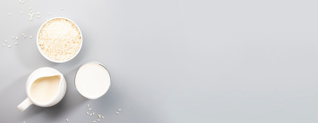 Rice milk with rice grains on gray table. Copy space, top view